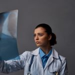 doctor in medical gown with x ray on gray background research in laboratory high quality photo