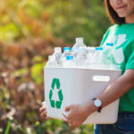 hermosa mujer asiatica recogiendo basura sosteniendo papelera reciclaje botellas plastico a